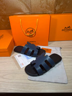 Hermes open-toe slide sandals, dark blue leather with three wide strap panels and H logo sole.