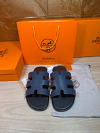 Hermes open-toe slide sandals, dark blue leather with three wide strap panels.