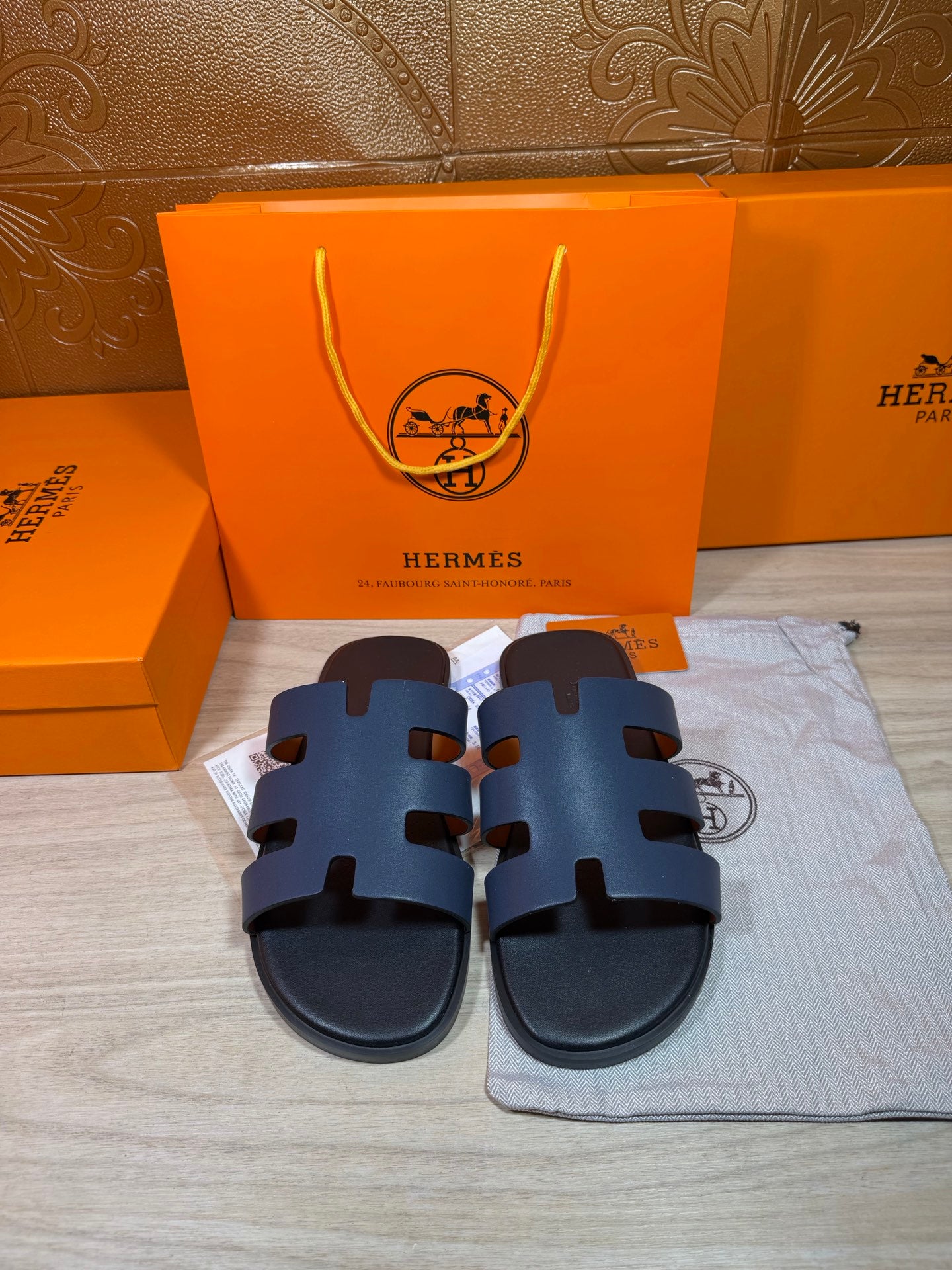 Hermes open-toe slide sandals, dark blue leather with three wide strap panels.