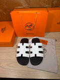 Hermes slide sandals with white cutout straps and black footbeds