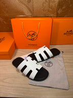 Hermes sandals with white strap pattern and black footbed, side view