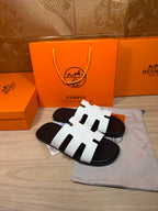 Hermes slide sandals with three white straps and black rubber sole