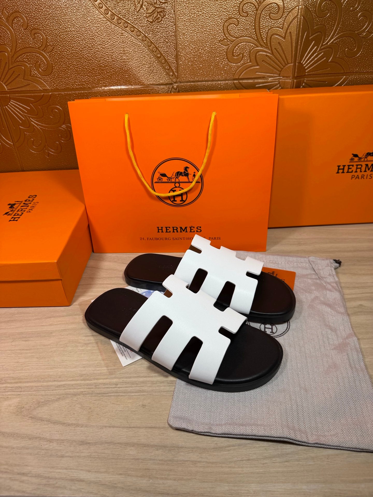 Hermes slide sandals with three white straps and black rubber sole