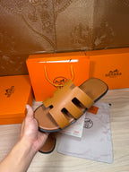 Hermes tan-brown leather slide sandals with openwork H straps, side view