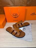 Hermes tan-brown leather slide sandals with openwork H straps, flat sole