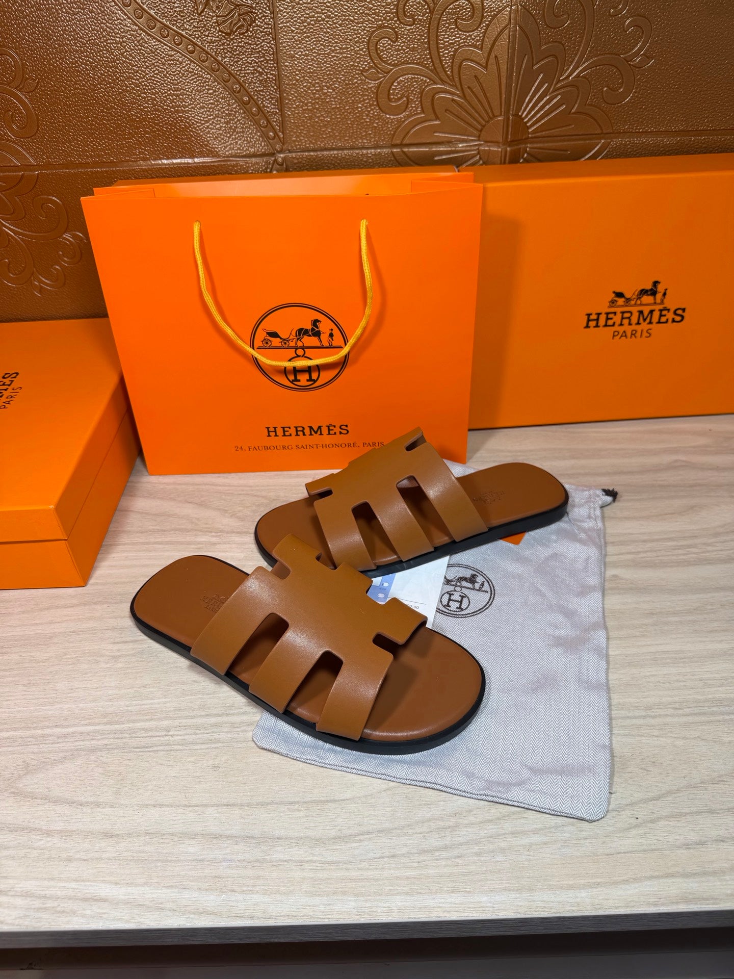 Hermes slide sandals with openwork H design, tan-brown leather, flat sole