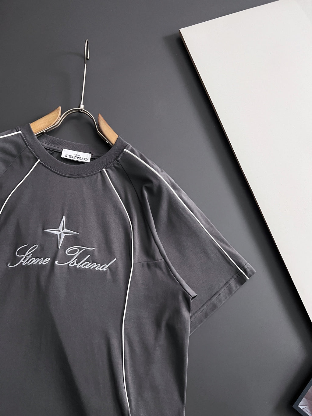 Stone Island dark gray T-shirt on hanger with star and script logo