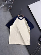T-shirt with white body, navy raglan sleeves, and small embroidered logo on chest