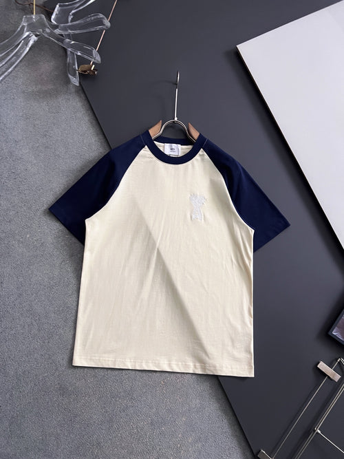 T-shirt with white body, navy raglan sleeves, and small embroidered logo on chest