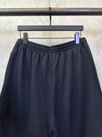 Black elastic-waist shorts with drawstring and pleated front detail
