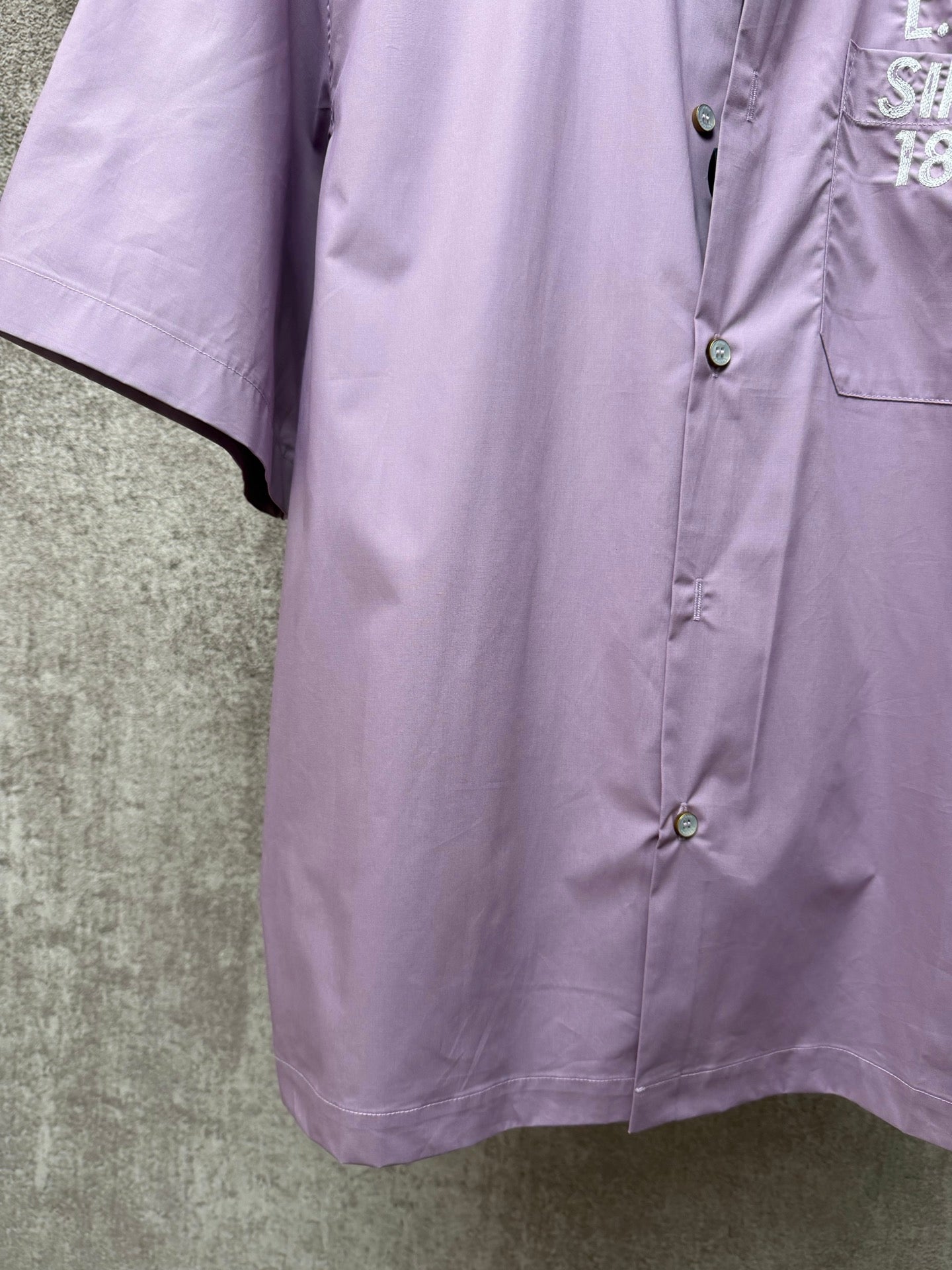 Men's short-sleeve button-up shirt in lavender, side view and curved hem