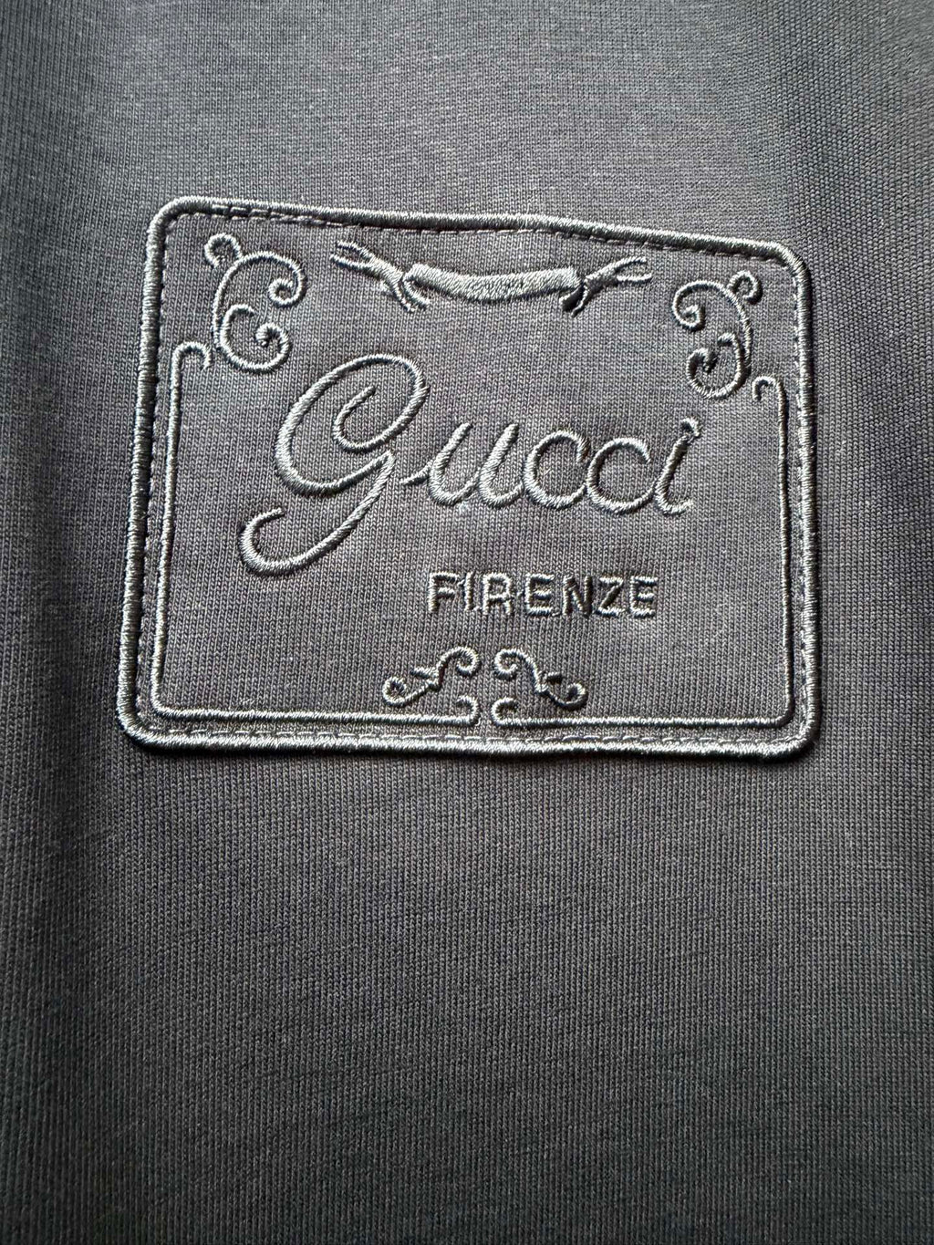 Embroidered Gucci Firenze logo label patch on dark fabric