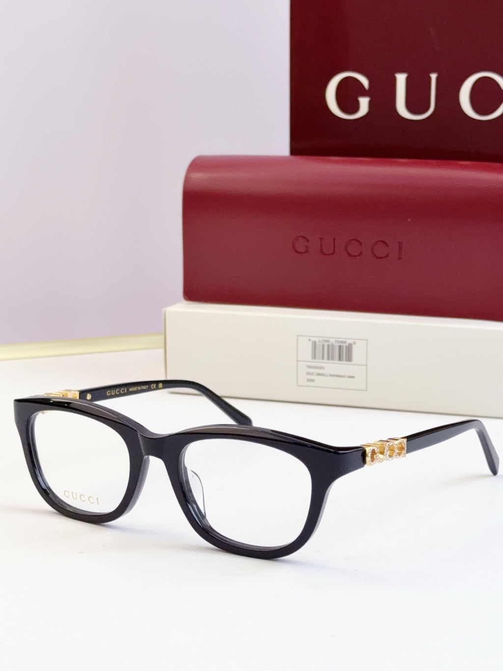 Gucci eyeglasses with black frames and gold chain detail at the temples