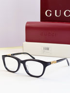 Gucci eyeglasses with black frames and gold chain detail at the temples