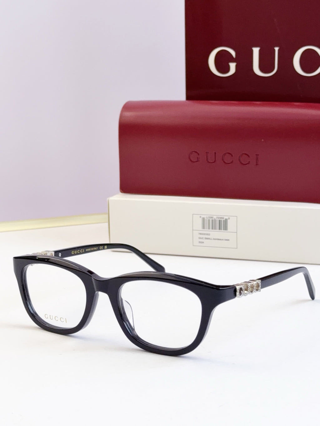 Gucci eyeglasses with glossy black frames and gold chain temple detail