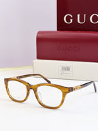 Gucci eyeglasses with clear amber frames and gold chain temple detail