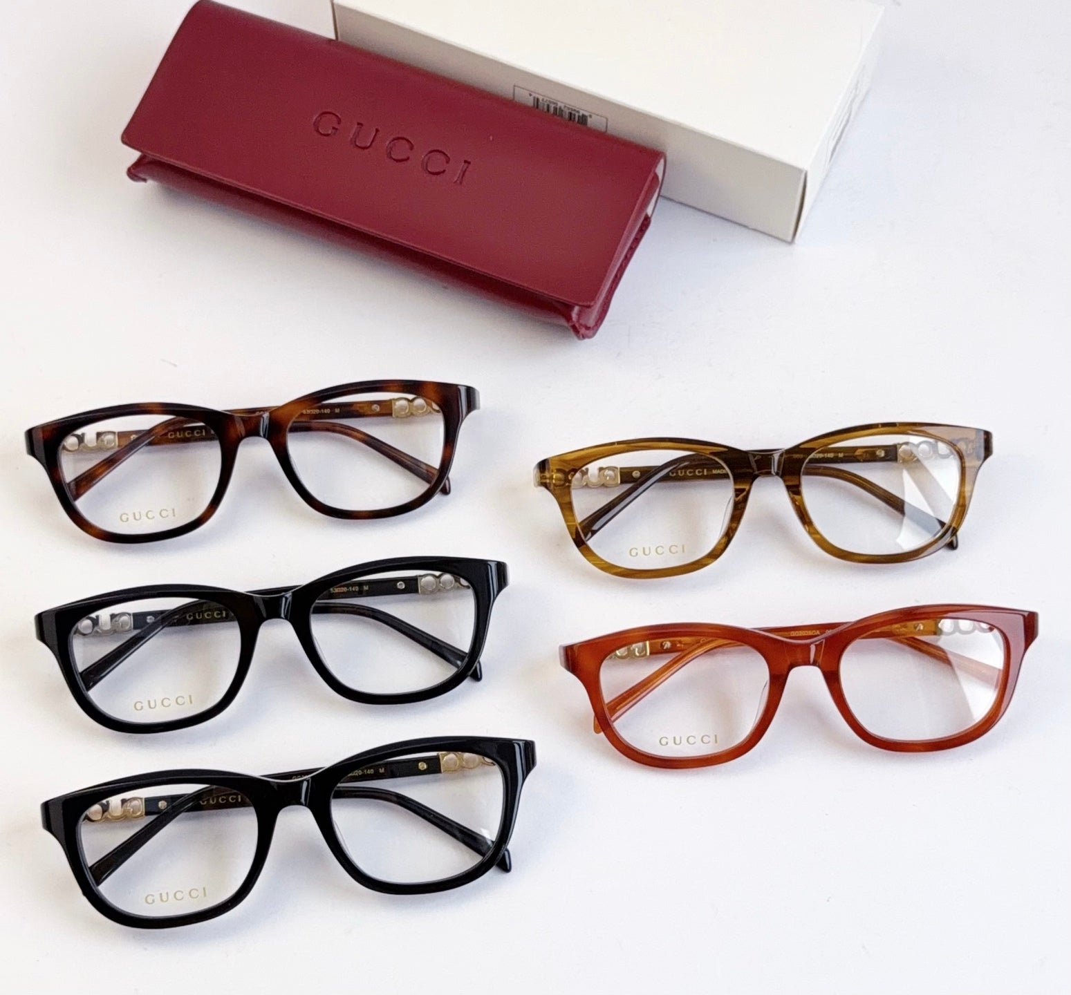 Set of Gucci eyeglasses with black, tortoise, and amber frames, gold accents on temples