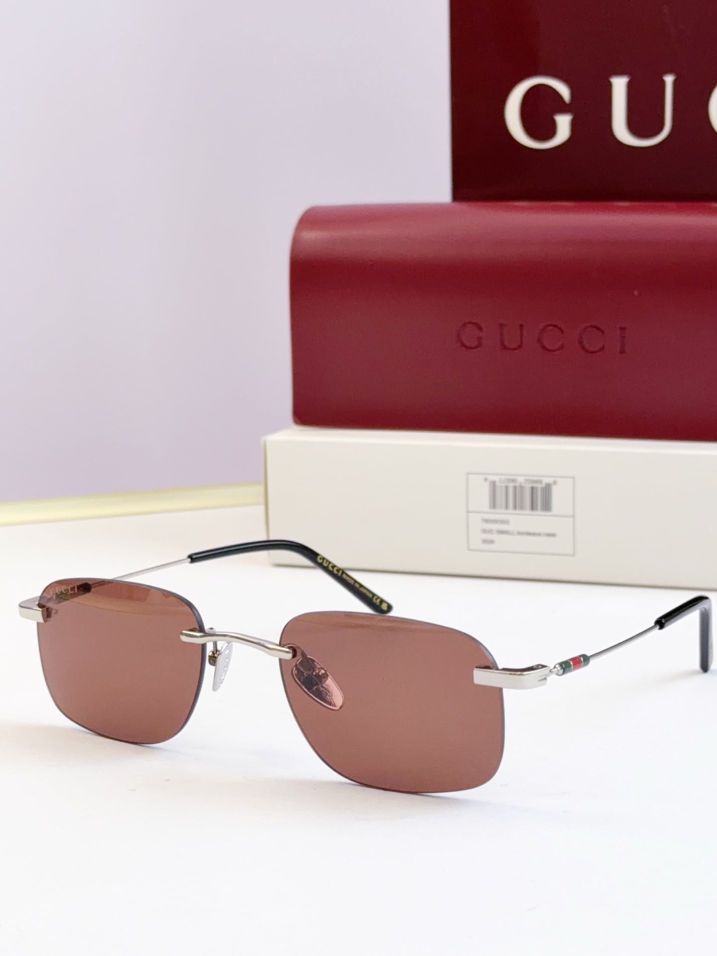 Sunglasses with gold-tone metal frame and brown tinted lenses, thin arms
