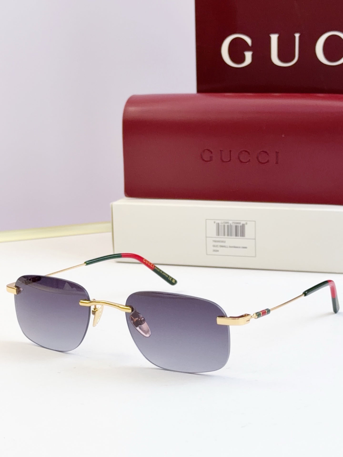 Sunglasses with gold-tone frame, dark lenses, multicolor detail on temple tips