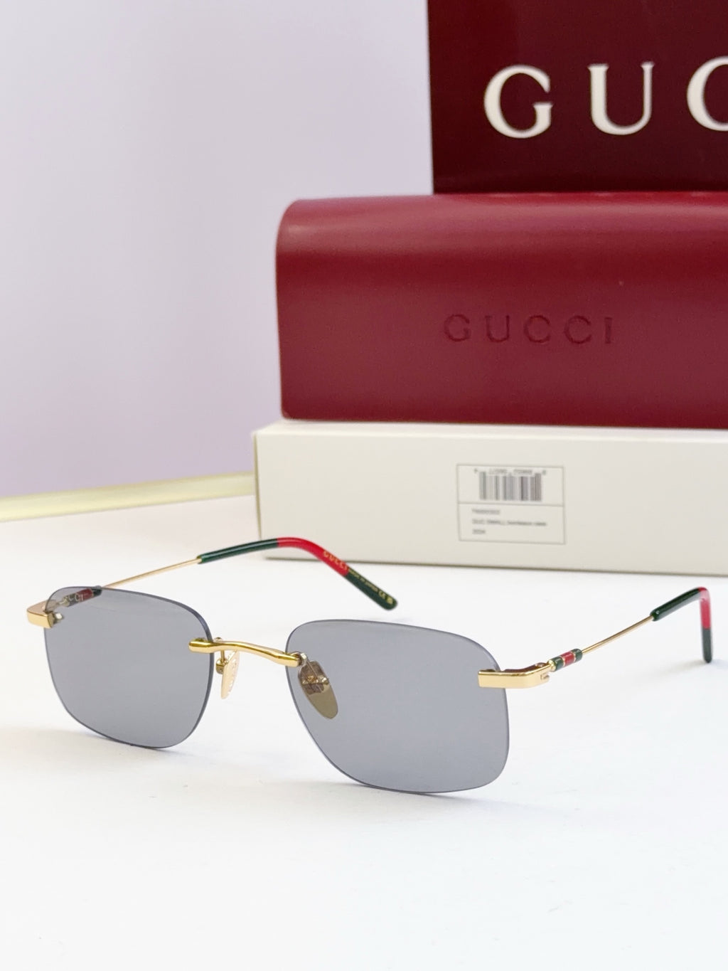 Sunglasses with gold-tone metal frame and light gray tinted lenses, slim temples