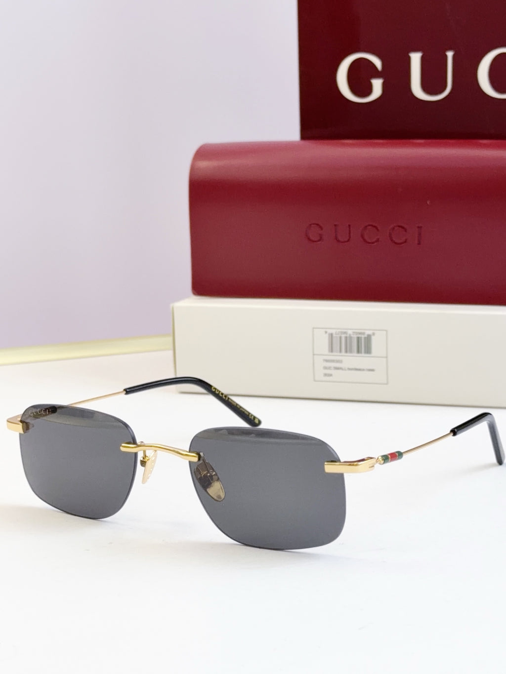 Gucci sunglasses, gold-tone metal frame with dark gray tinted lenses and thin temples