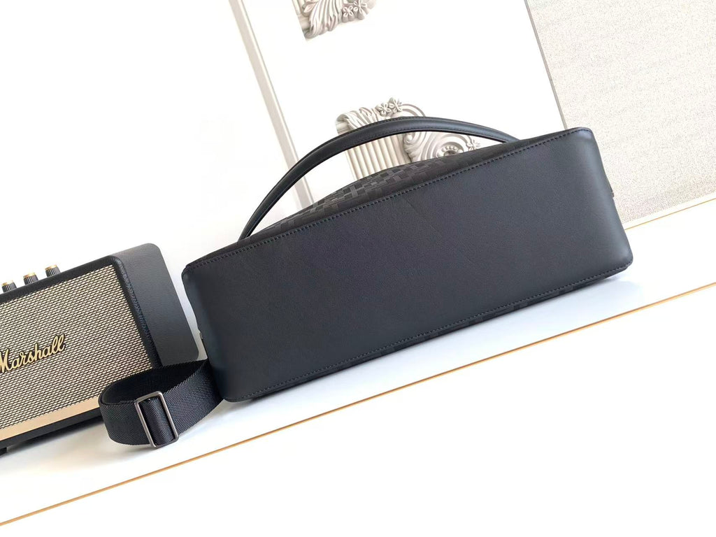 Dark leather baguette bag with top handle and adjustable crossbody strap