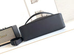 Dark leather baguette bag with top handle and adjustable crossbody strap