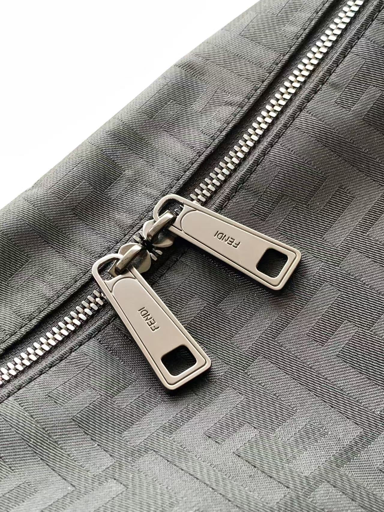 Fendi logo fabric bag close-up with double zippers and metal pull tabs