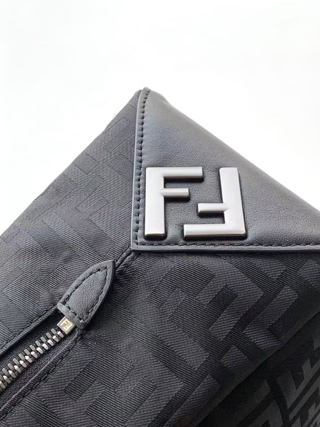 Fendi FF logo patch on dark patterned bag with zipper edge detail