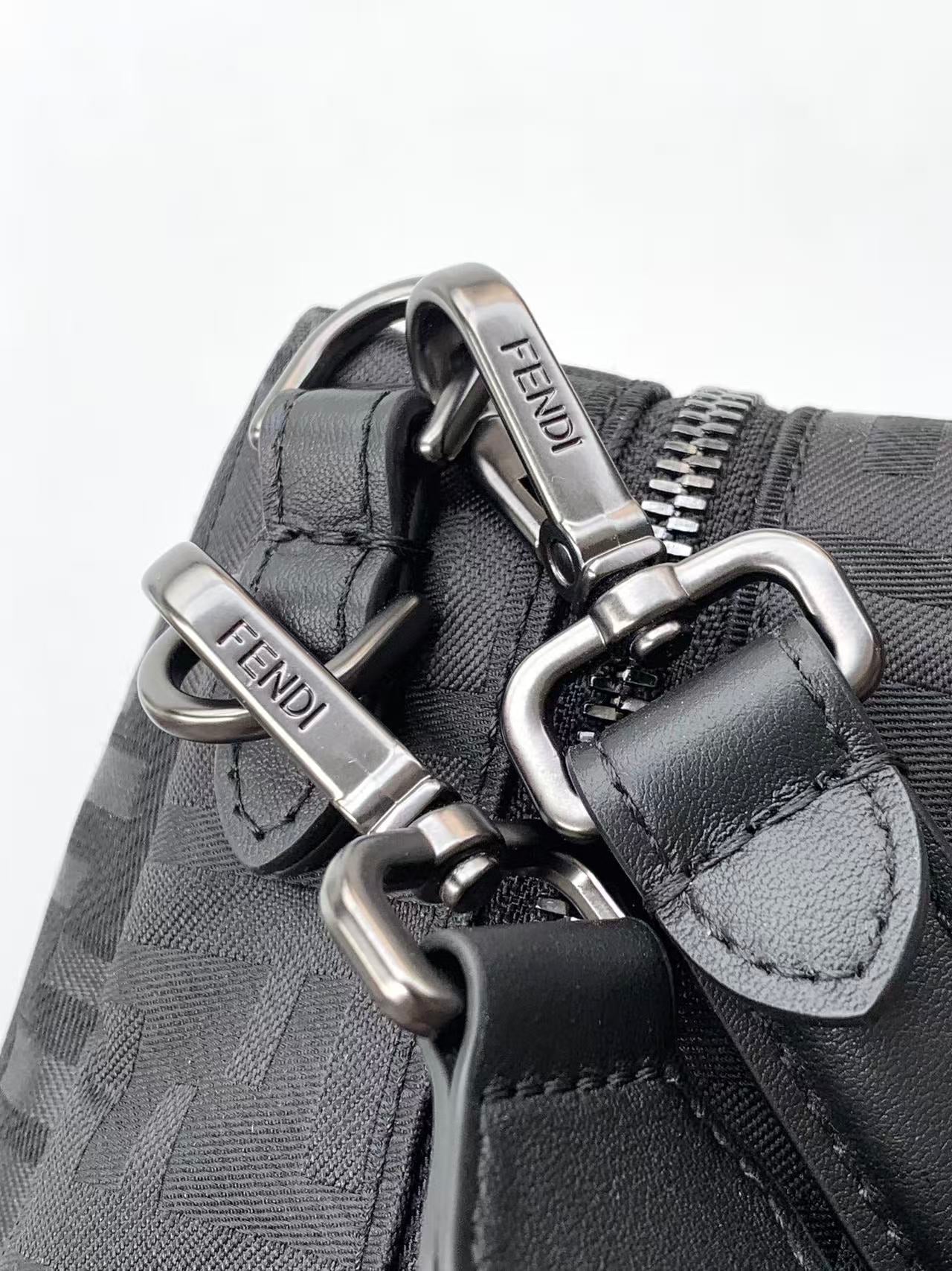 Fendi bag hardware close-up with metal clips, buckles, and logo label