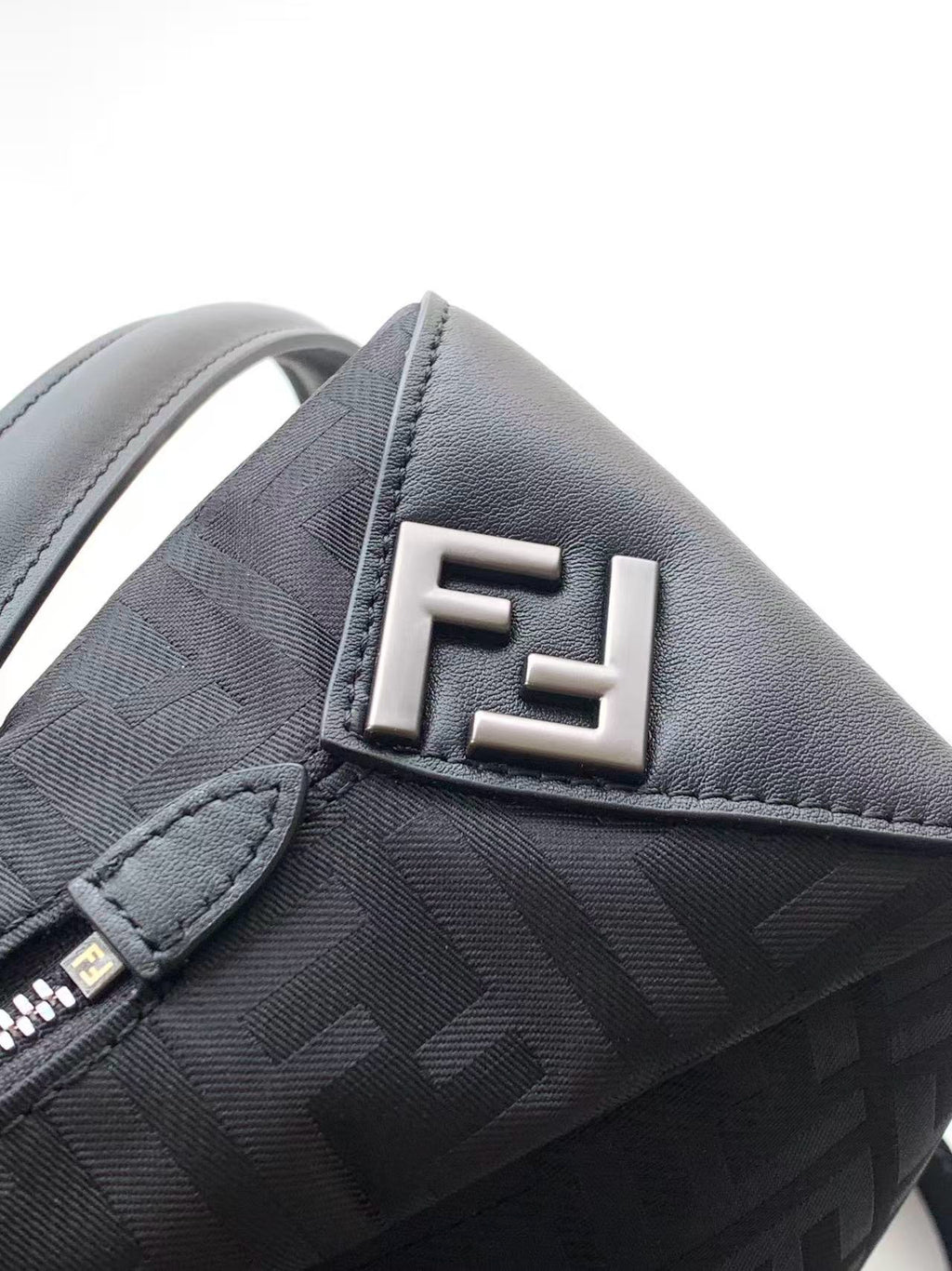 Fendi bag close-up of FF logo in silver on textured gray fabric