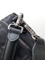 Fendi bag close-up of strap hardware and zipper pull, gray fabric with logo