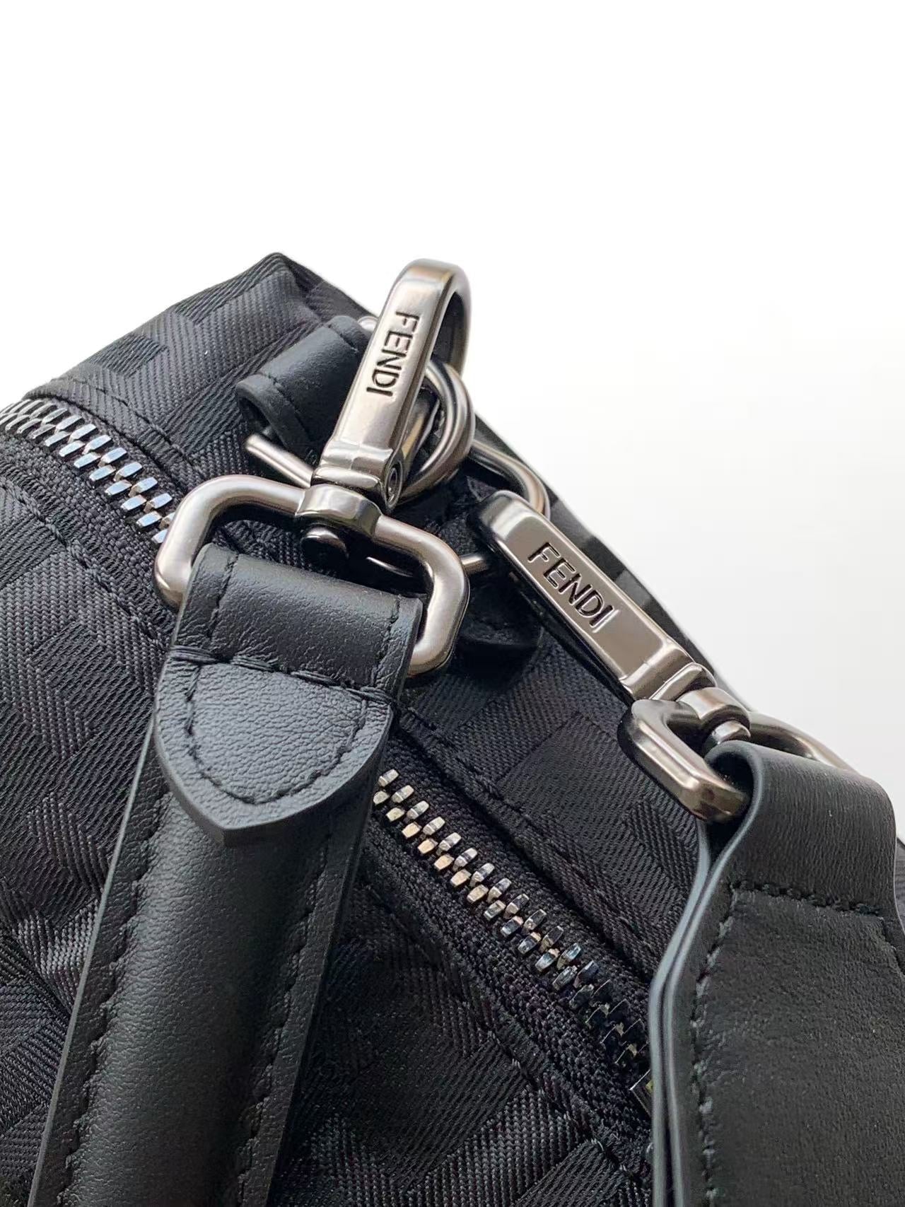 Fendi bag close-up of strap hardware and zipper pull, gray fabric with logo