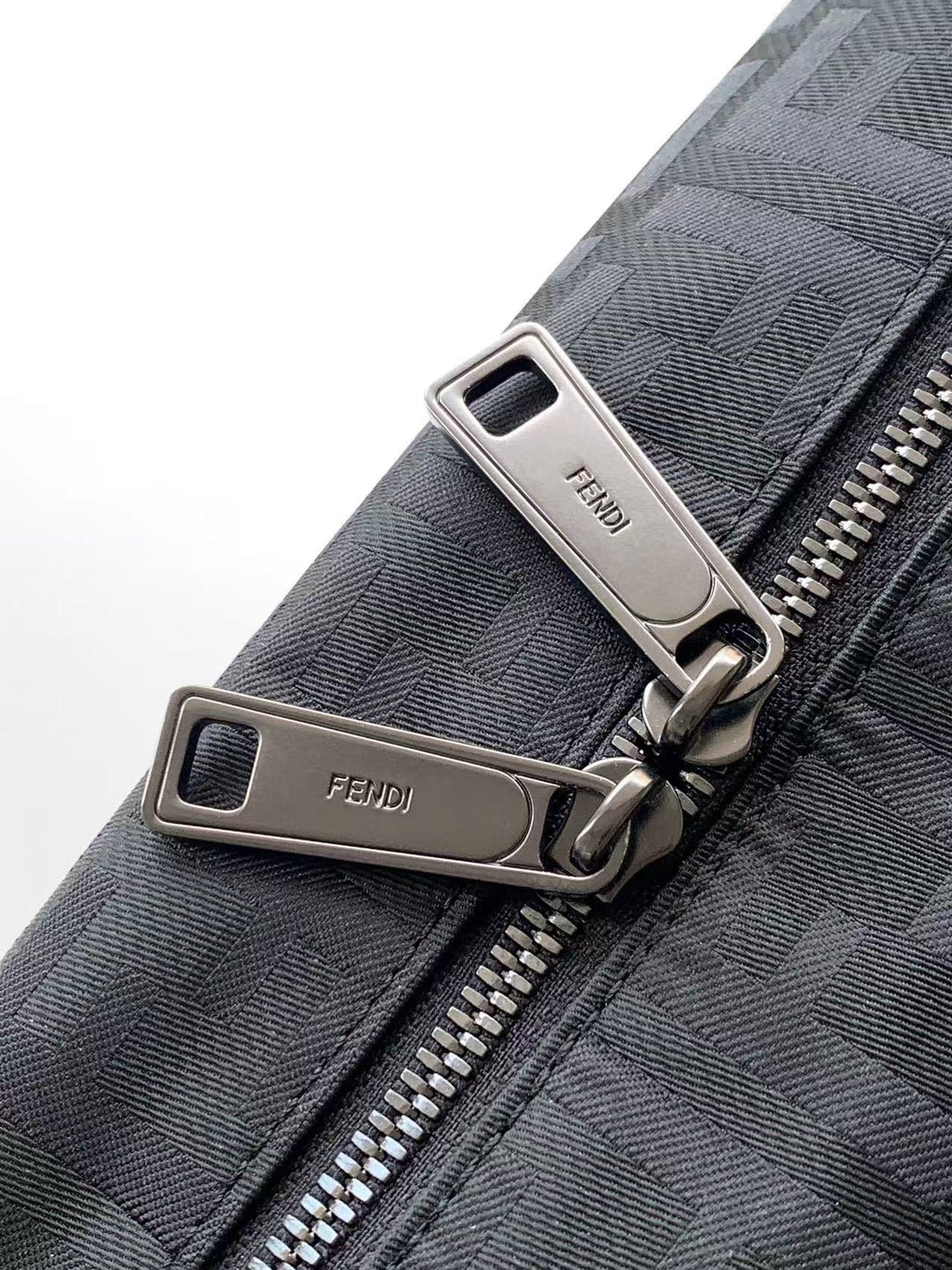 Fendi bag zipper pulls with silver hardware on gray textured fabric