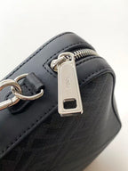 Fendi bag detail: silver zipper pull with rectangular brand tag on dark leather.