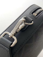 Fendi bag detail: silver clasp and zipper on dark leather with stitched edges.