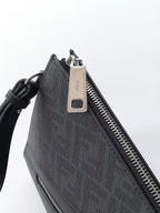 Fendi bag close-up of zipper pull and metal tag on dark textured fabric with leather trim.