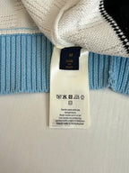 Long knit garment with cream and blue stripes, inner care label at neckline