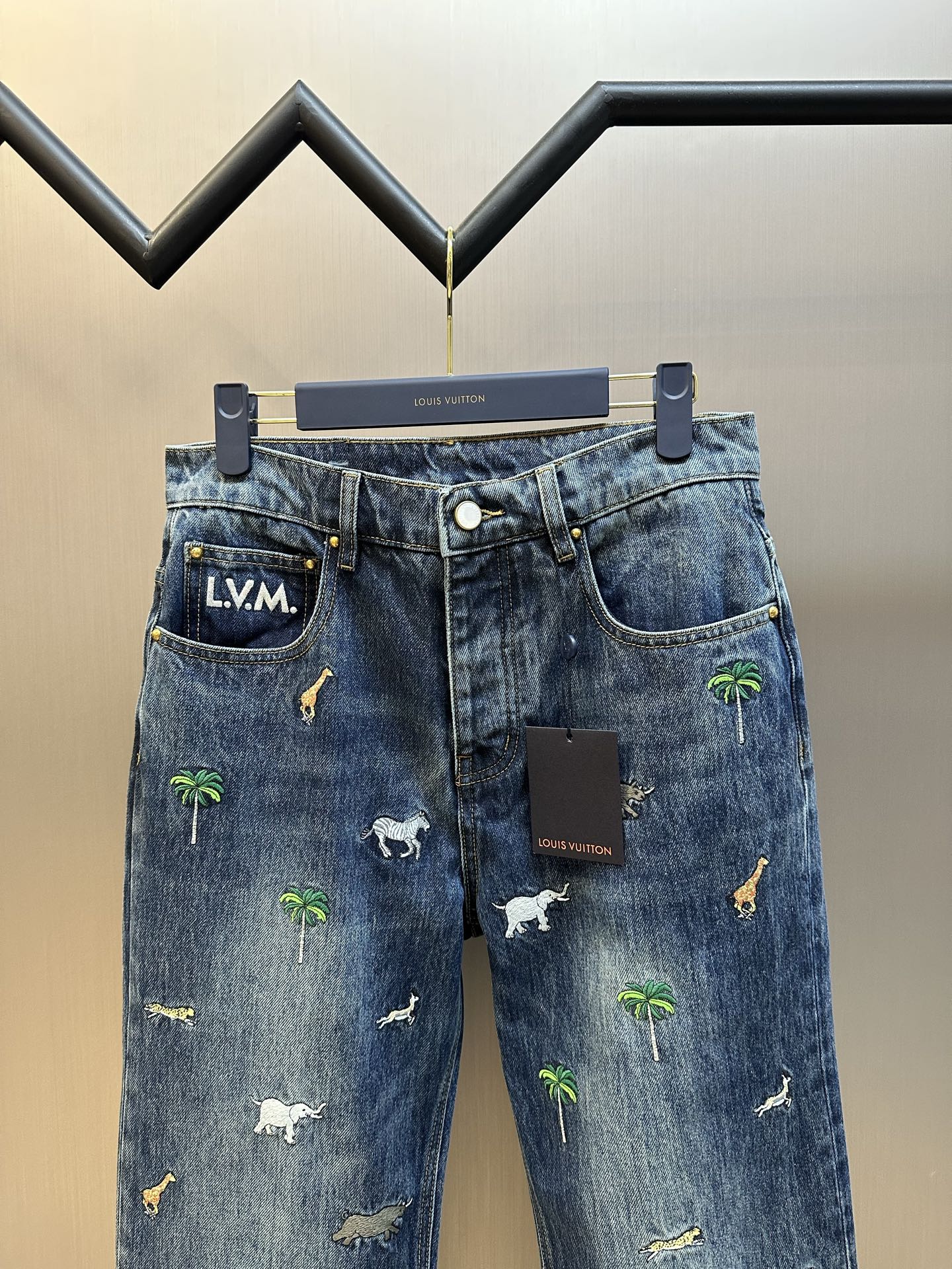 Blue denim pants with L.V.M. waistband patch and animal palm prints