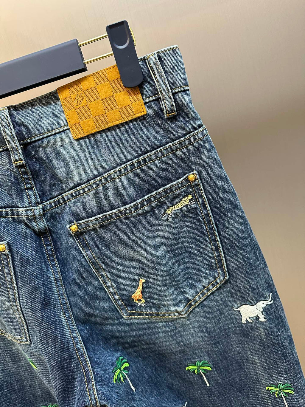 Blue denim jeans with front pocket and small animal print motifs