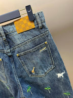 Blue denim jeans with front pocket and small animal print motifs