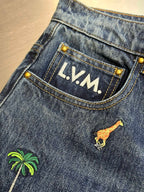 Blue denim jeans with LV.M. patch on waistband and giraffe graphic