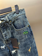 Blue denim jeans with zip fly, front pocket, and palm tree print