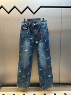Blue denim pants with scattered animal and palm tree patches, front view