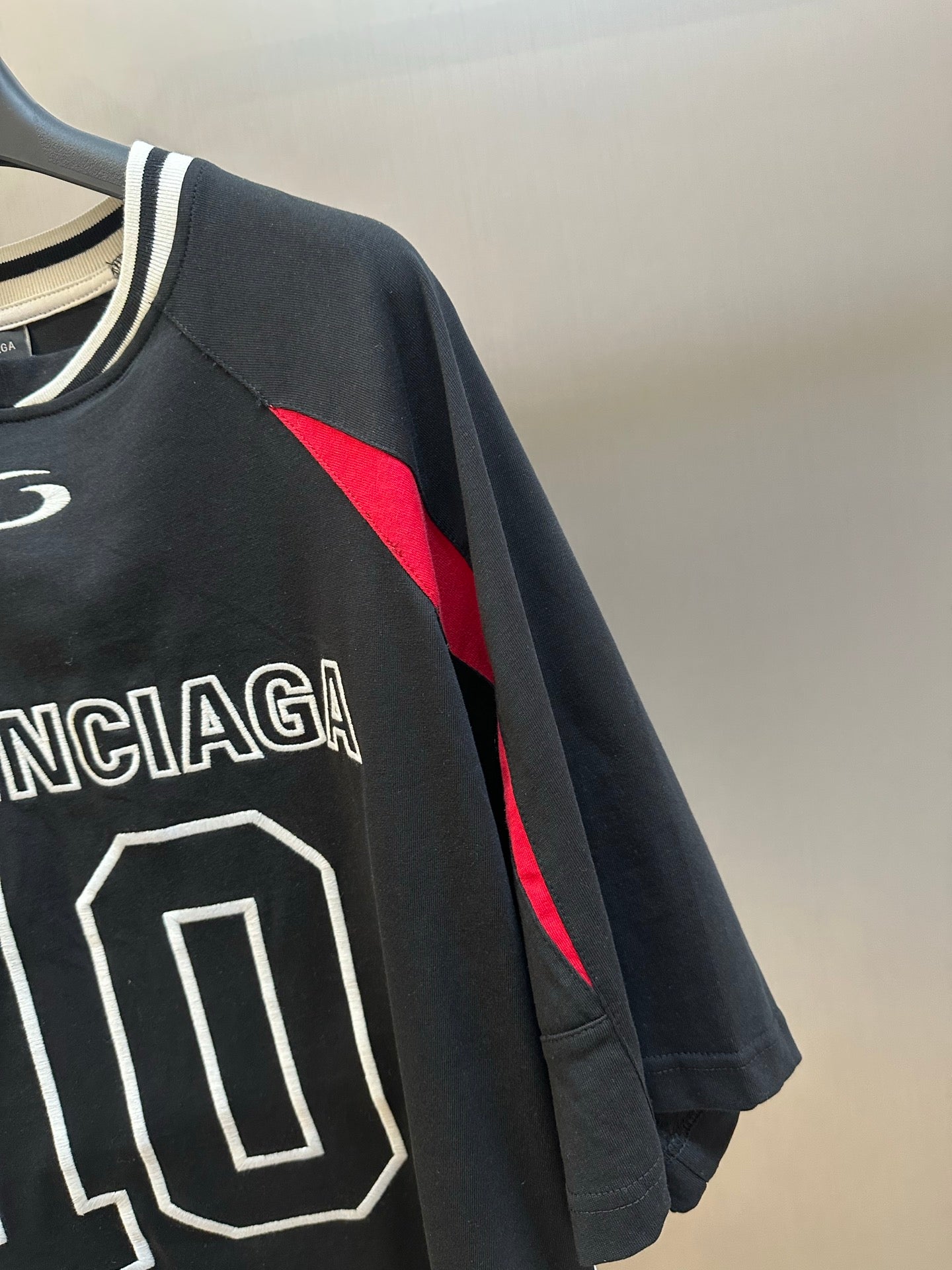 Balenciaga black jersey sleeve with red graphic panel and partial 110 front print