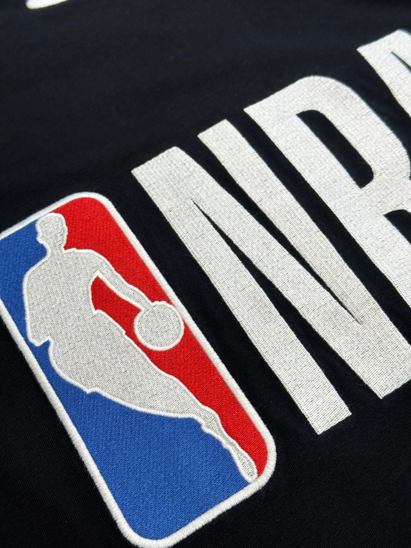 Balenciaga black jersey with NBA logo patch in red, blue, and white on front