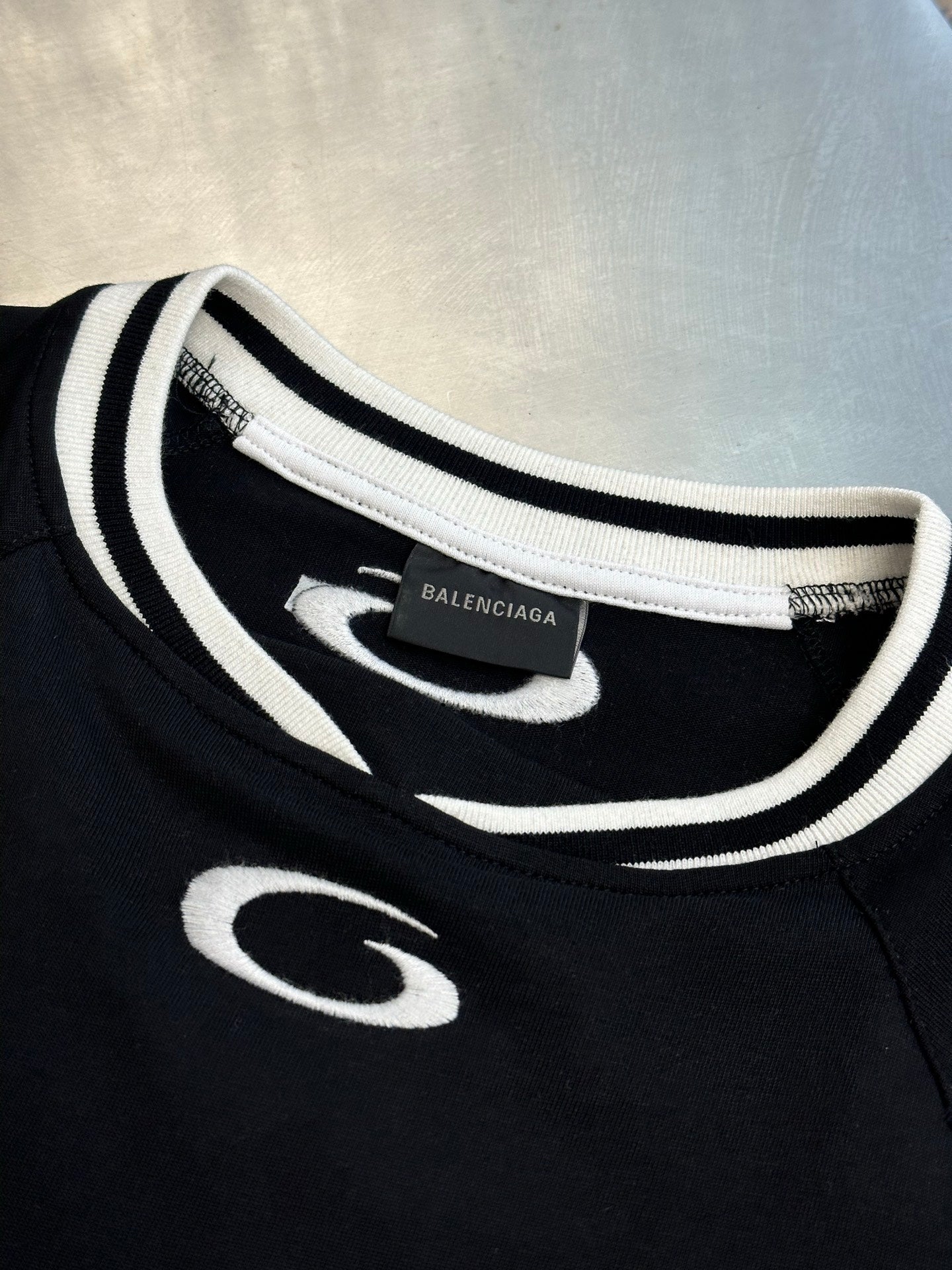 Balenciaga black jersey neckline with white and black striped trim and small front logo