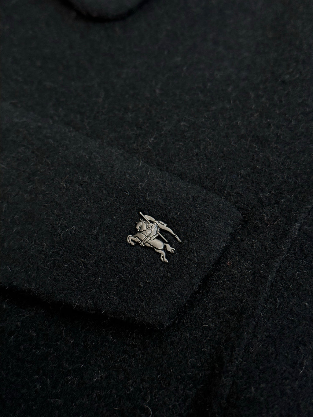 Burberry coat chest logo patch on dark fabric
