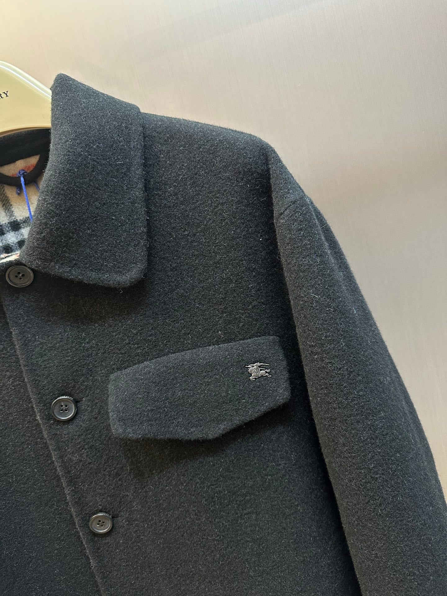 Burberry coat close-up of shoulder and chest pocket with dark fabric