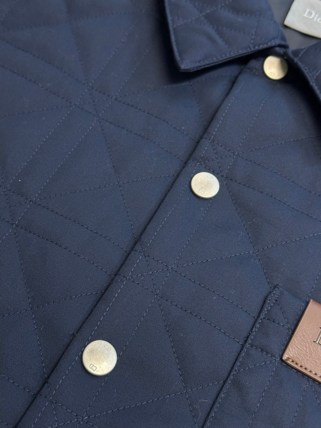 Quilted long jacket front with dark navy buttons and brown Dior leather patch